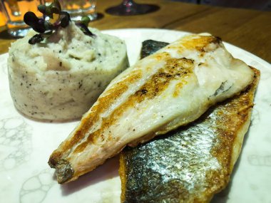 Patates püresiyle ızgara balık ve marul karışımı.