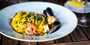 Vongole ile taze deniz ürünleri makarnası, deniz ürünleri, taze sebze, sarımsak, maydanoz ve baharat karışımı.