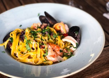 Vongole ile taze deniz ürünleri makarnası, deniz ürünleri, taze sebze, sarımsak, maydanoz ve baharat karışımı.