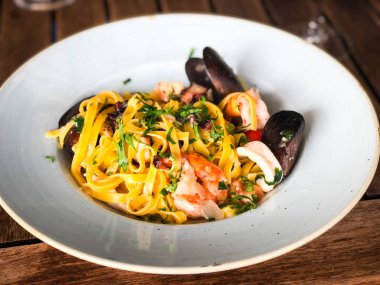 Vongole ile taze deniz ürünleri makarnası, deniz ürünleri, taze sebze, sarımsak, maydanoz ve baharat karışımı.