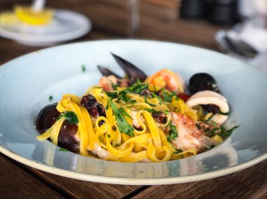 Vongole ile taze deniz ürünleri makarnası, deniz ürünleri, taze sebze, sarımsak, maydanoz ve baharat karışımı.