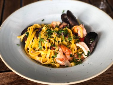 Vongole ile taze deniz ürünleri makarnası, deniz ürünleri, taze sebze, sarımsak, maydanoz ve baharat karışımı.