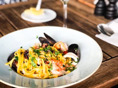 Vongole ile taze deniz ürünleri makarnası, deniz ürünleri, taze sebze, sarımsak, maydanoz ve baharat karışımı.