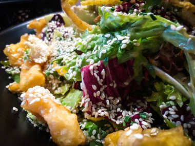 Kızarmış soğan halkalarıyla salatayı karıştır.