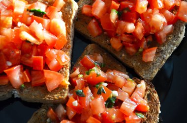 Lezzetli ev yapımı domates bruschetta ve taze sarımsaklı fesleğen.