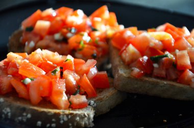 Lezzetli ev yapımı domates bruschetta ve taze sarımsaklı fesleğen.