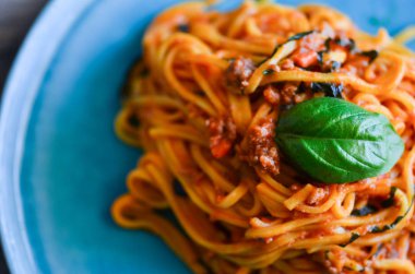 Lezzetli İtalyan bolonez spagettisi ve taze sebze ve fesleğen.