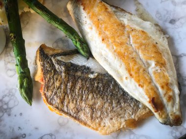 Kızarmış balık ve patates ezmeli kuşkonmaz.