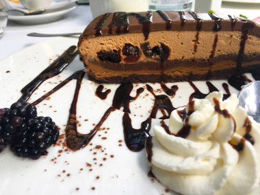 Koyu kirazlı ve taze böğürtlenli lezzetli ev yapımı çikolatalı pasta.