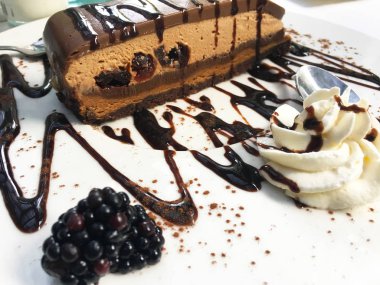 Koyu kirazlı ve taze böğürtlenli lezzetli ev yapımı çikolatalı pasta.