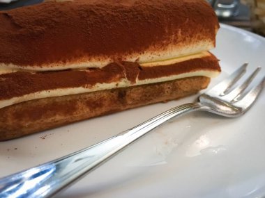 Lezzetli İtalyan tiramisusu yakından zevk alır.