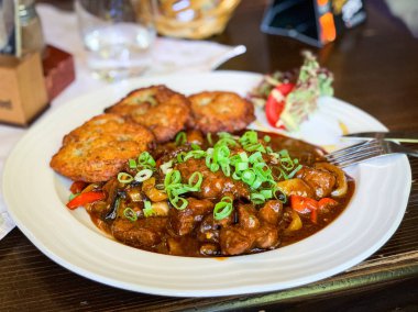 Kızarmış patates ve taze soğanlı geleneksel czech gulaş tabağı