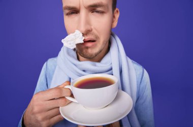 Sick man with anti-influenza tea in hands