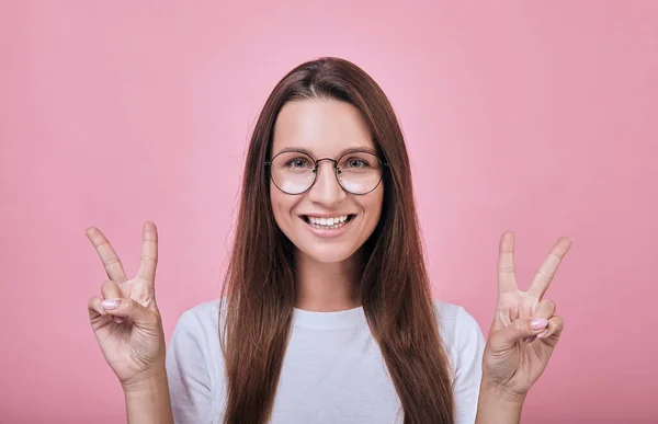 Cool girl smiling slightly and shows fingers peace — Stock Photo, Image