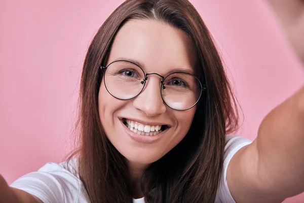 Cool lady in round glasses holds camera with her hands and takes a selfie — Stock Photo, Image
