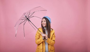 Şemsiyeli neşeli bayan yukarı bakıyor ve gülümsüyor.