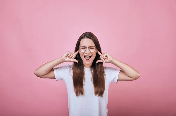 Funny woman covered her ears with the index fingers of both hands and screaming — Stock Photo, Image