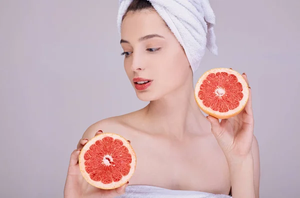 A fiatal szépség kezében van egy lédús grapefruit.. — Stock Fotó