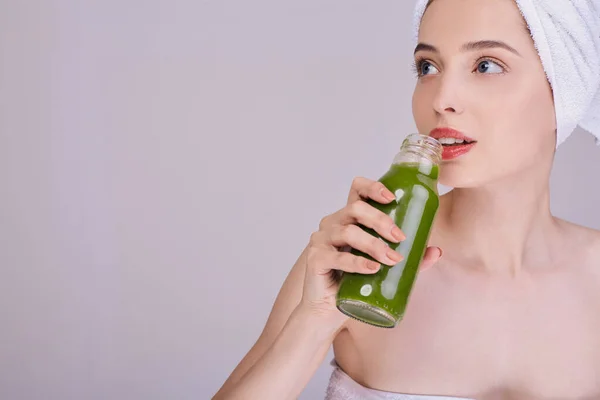 Signora dopo una doccia gode di un frullato verde in una bottiglia . — Foto Stock