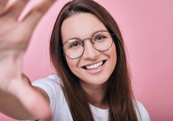 Cool girl in glasses in T-shirt and glasses takes a selfie — Stock Photo, Image