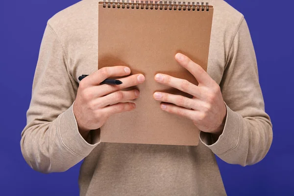 The guy's hands holding ballpoint pen and brown draft notebook — Stock Photo, Image