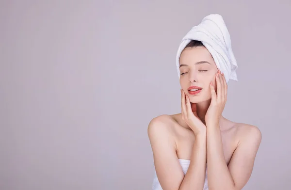 Sensual morena em uma toalha branca toca seu rosto . — Fotografia de Stock