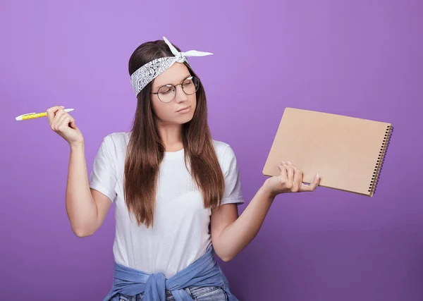 A young student holds in her hands writing instruments for study. — Stock Photo, Image