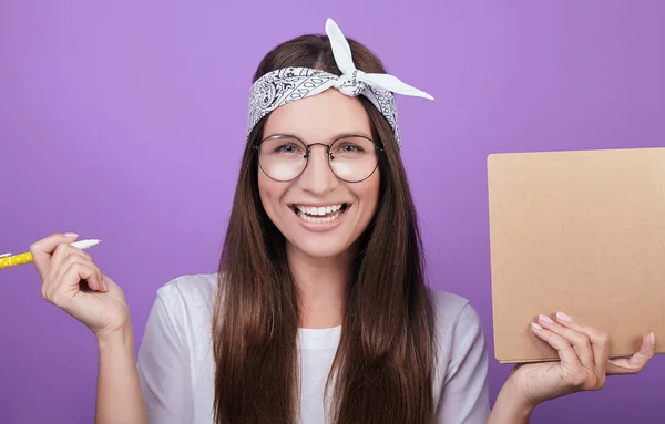 Smiling girl holding a pen and notebook for study. — Stock Photo, Image