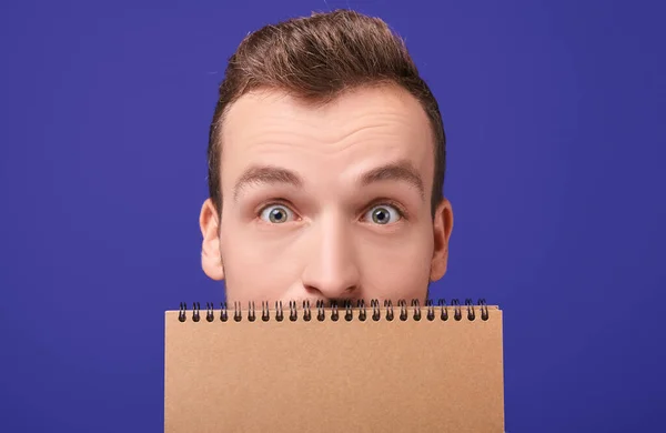 Surprised guy with a craft notebook. — Stock Photo, Image