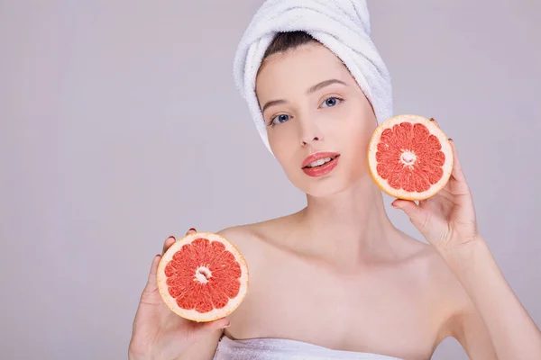 Szépség portré egy lány grapefruit az arc közelében. — Stock Fotó