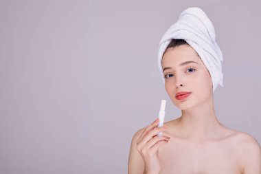 Arka planda dudak kremi süren genç ve güzel bir bayan..