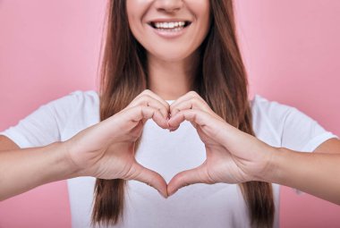 Kahverengi saçlı ve hafifçe gülümseyen tişörtlü çekici kız.