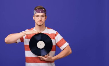 Gözlüklü yakışıklı adamın elinde müzik kaydı var..
