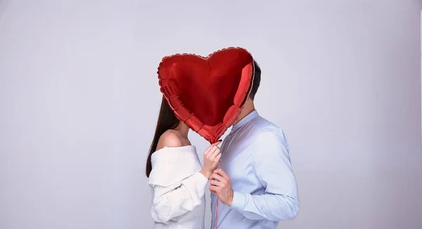 Aşk öpücüğü, kalp şeklinde kırmızı bir topun arkasına saklanır..