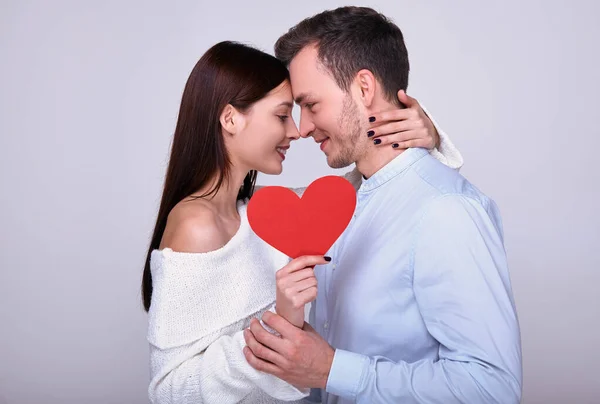 Primer plano de una pareja abrazada con un corazón rojo . — Foto de Stock
