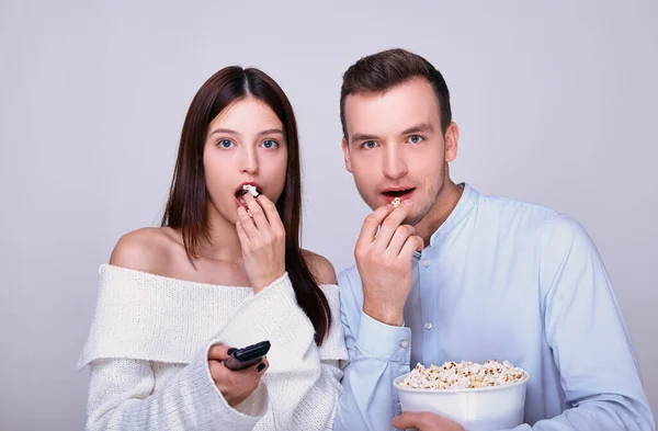 Genç çift birlikte durup film izliyor, patlamış mısır yiyor..