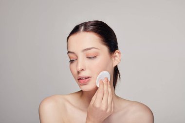 Yakından genç, narin, sakin bir kız. Sağ elinde pamuk tutacağı var. Düşünerek başını çeviriyor.