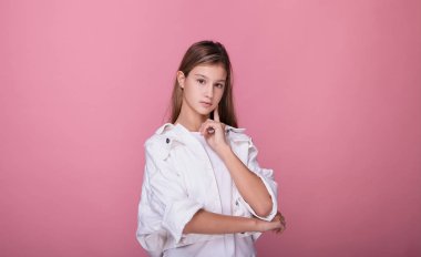 Güzel bir genç kız sakin ve kendinden emin bir şekilde dik dik bakıyor..