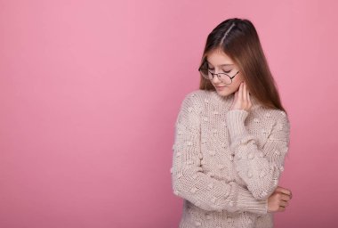 Bej kazaklı narin genç kız aşağı bakıyor..