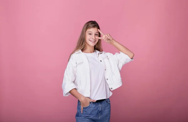 Girl posing on a pink background. — ストック写真