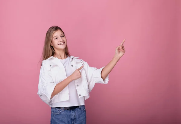 Una adolescente se ve recta y muestra su mano a un lado . — Foto de Stock