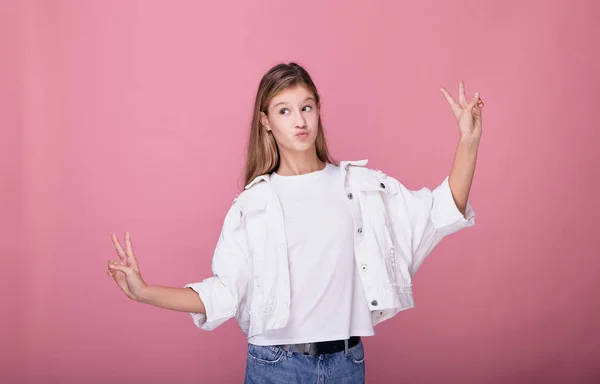 La niña dobló sus labios en un beso y muestra signos de paz . —  Fotos de Stock