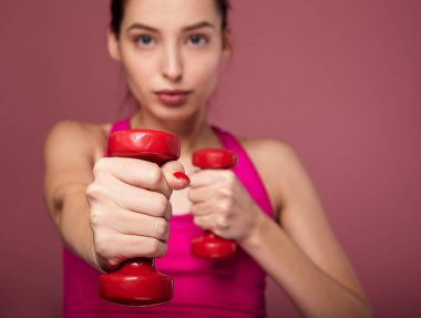 Alıştırma yaparken dambıl kullanan güzel bir kız..