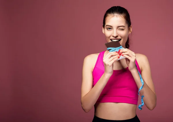 귀여운 운동 선수인 백인 여성 이 초콜릿 바를 먹고 있습니다. — 스톡 사진