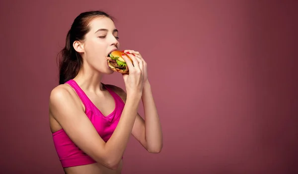 Young beautiful sexy woman eat sandwich with pleasure. — Stock Photo, Image