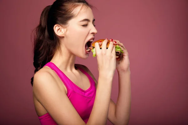 Hungry woman holding big burger. — Stock Photo, Image