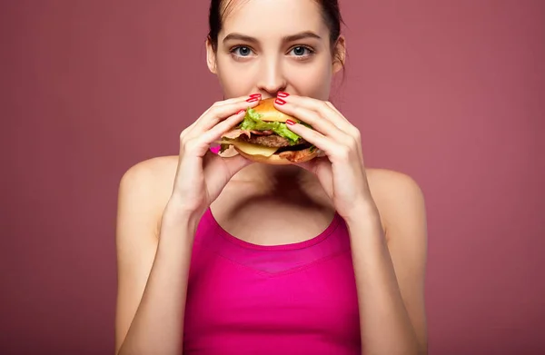 Good-looking woman eating cheeseburger. — Stock Photo, Image