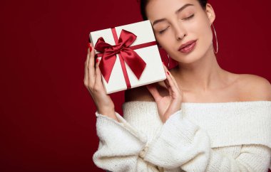 Kibar genç bir bayan kırmızı arka planda bir yüz ifadesi taşıyor..