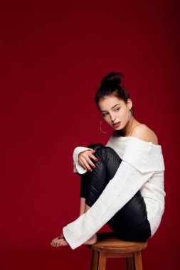 Romantik beyaz kız kırmızı arka planda bir sandalyede oturuyor..