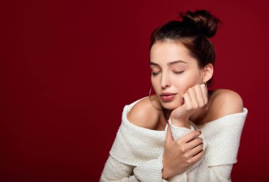 Kafkas kadın modelinin portresi kırmızı arka planda gözleri kapalı duruyor..